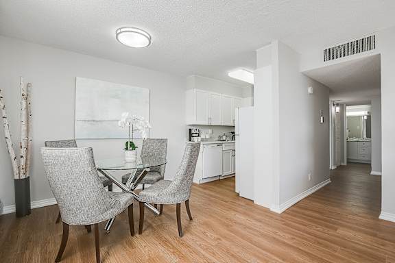 a dining room with a glass table and chairs