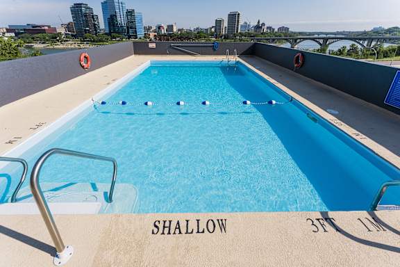a swimming pool on the roof of a building with a city in the background