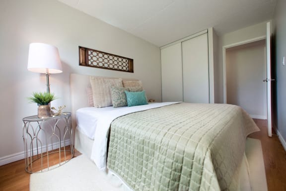 a bedroom with a bed and a nightstand with a lamp