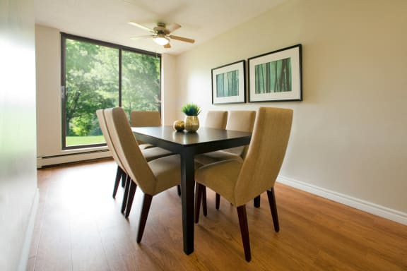 a dining room with a table and chairs and a window