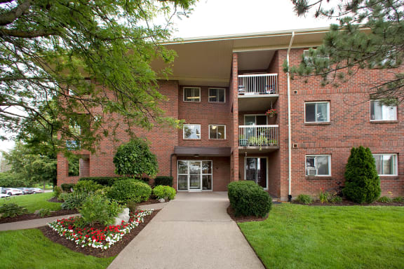 a sidewalk in front of a brick apartment building