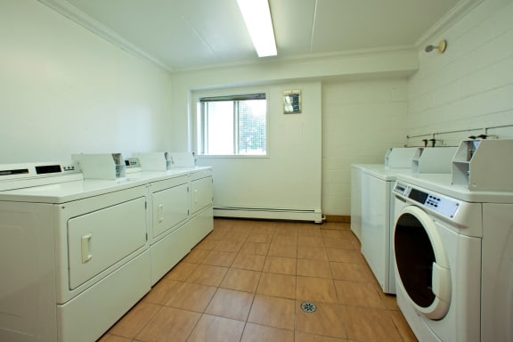 a laundry room with washes and dryers and a window