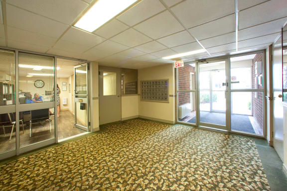 a room with a large carpeted floor and glass doors