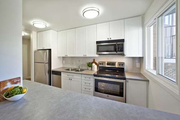 a kitchen with white cabinets and stainless steel appliances