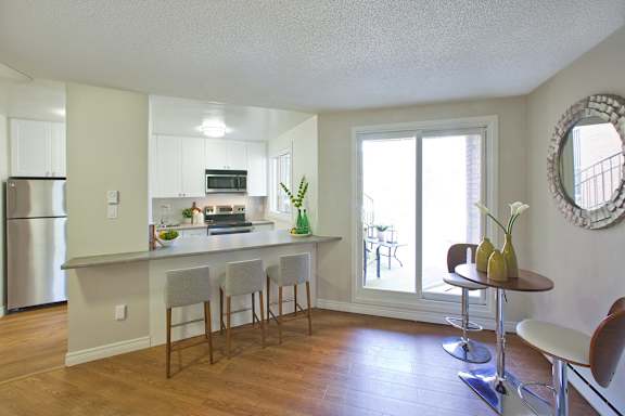 an open kitchen and living room with a breakfast bar and a large window