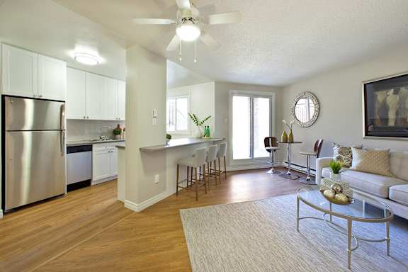 the view of a living room and kitchen with a ceiling fan