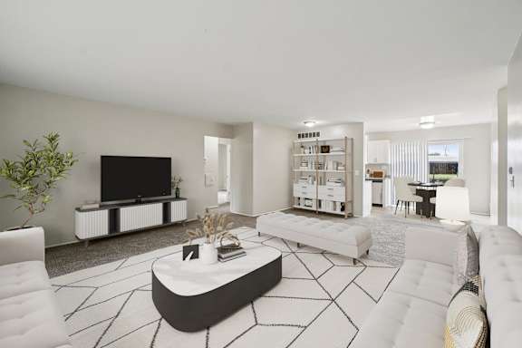 A modern living room with a white sofa, a black coffee table, and a flat-screen TV.