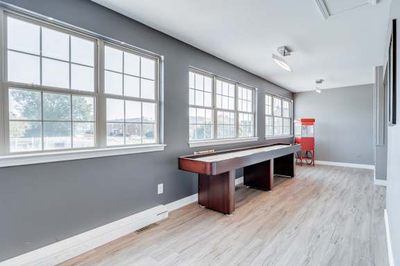 A room with a long table and a television on the wall.