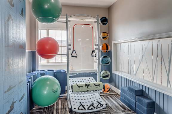 A gym with a green and red ball hanging from the ceiling.