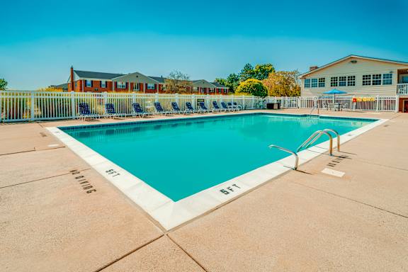A large outdoor swimming pool with a white border and blue water.
