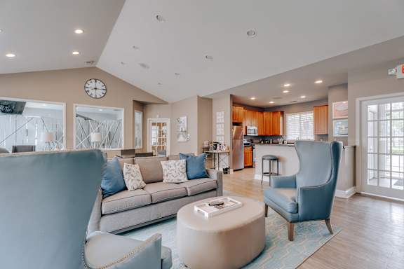 A living room with a grey couch, a blue armchair, and a coffee table.