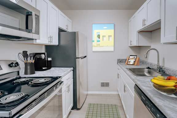 A kitchen with a black stove top oven and white cabinets.