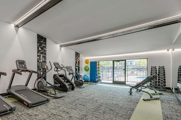 A gym with treadmills, elliptical machines, and other exercise equipment.