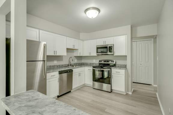 A kitchen with white cabinets and stainless steel appliances.