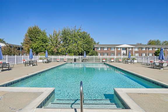 A large swimming pool with a metal ladder in the middle.