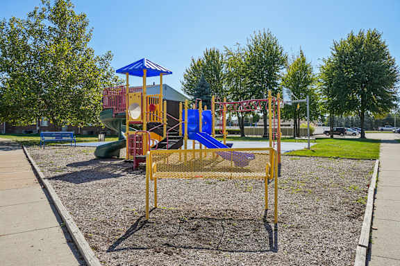A playground with a blue and yellow swing set.