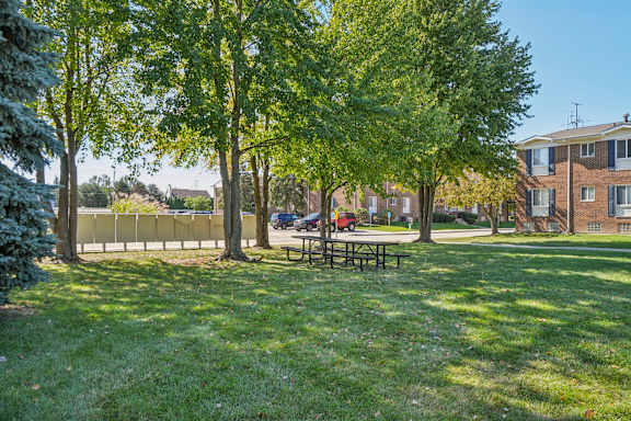 A park with a picnic table and trees.