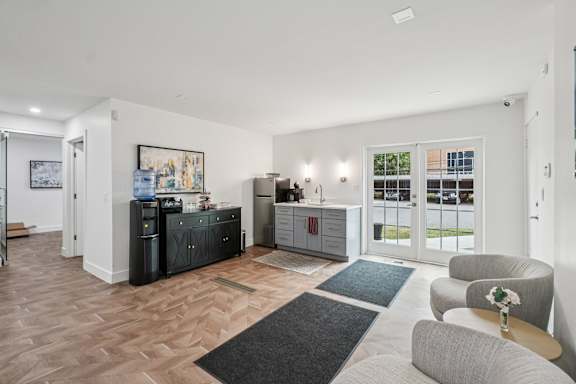 A living room with a grey couch and a black cabinet.