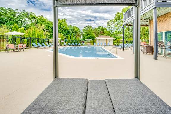 A large outdoor swimming pool with a view of the trees.