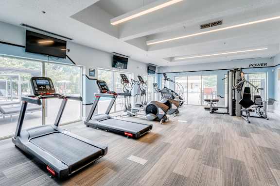 A gym with treadmills, exercise equipment, and a sign that says "POWER".