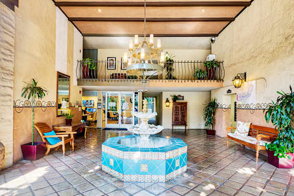 a lobby with a fountain and a chandelier