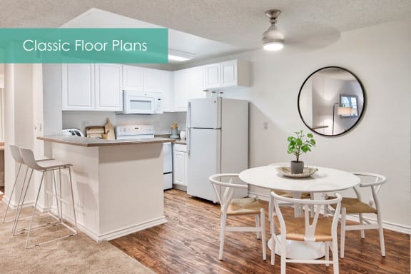 a white kitchen with a white table and chairs and a white refrigerator at The Meadows Apartments, Culver City , CA 90230