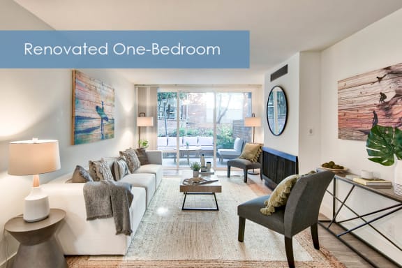 a living room with a white couch and a fireplace and the words renovated one bedroom at The Meadows Apartments, Culver City , CA 90230