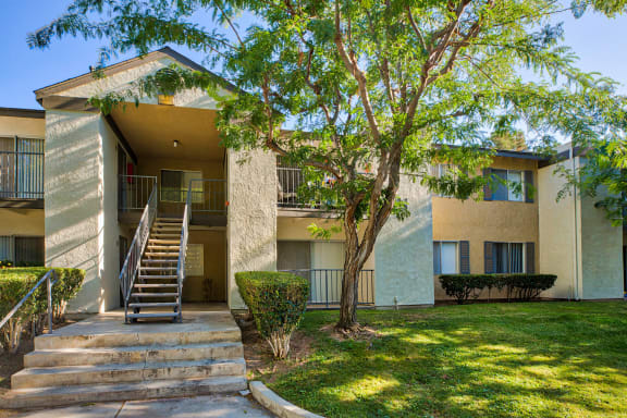 a building with stairs and a tree in front of it at Mountain Vista, Victorville, 92395