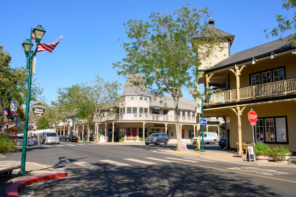 a city street with a stop sign and a building with a flag at Pleasanton Place, Pleasanton, CA, 94566