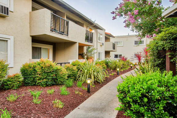 a walkway in front of an apartment building with a sidewalk  at Pleasanton Place, Pleasanton, California