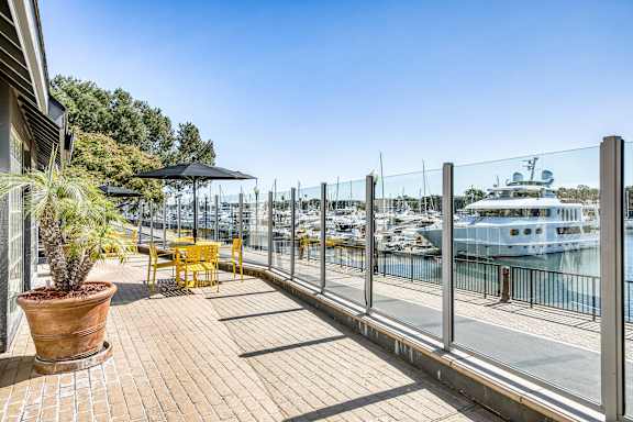 A patio with a table and chairs overlooking a marina.