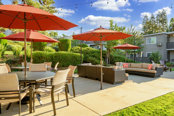 a patio with tables and chairs and umbrellas