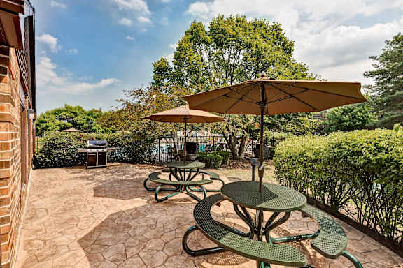 A patio with a table and chairs under an umbrella.