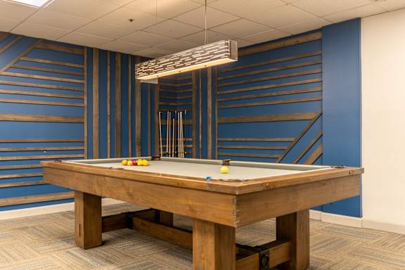 A pool table with a light hanging above it.