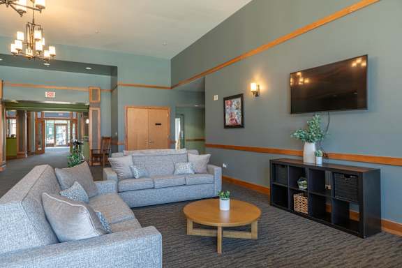 A living room with grey couches and a wooden coffee table.
