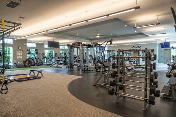 A gym with a variety of equipment including weights and cardio machines.