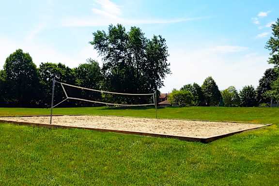 A volleyball net is set up on a sandy court.