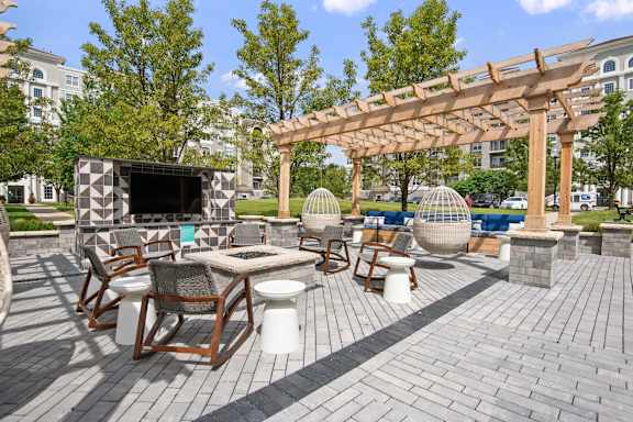 A patio with a table, chairs, and a pergola.