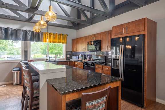 A kitchen with a black granite countertop and wooden cabinets.