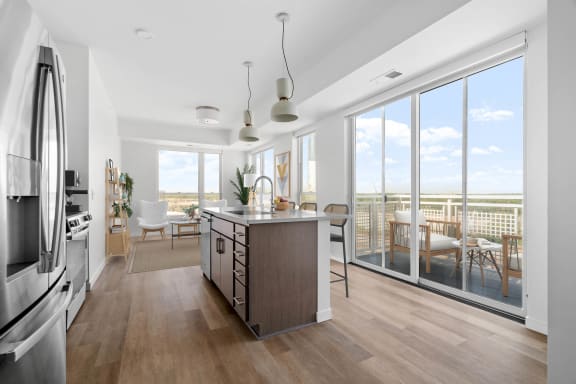 an open kitchen and living room with a view of a balcony