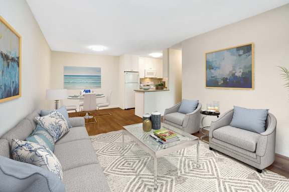 A living room with a grey couch, a coffee table, and a painting on the wall.
