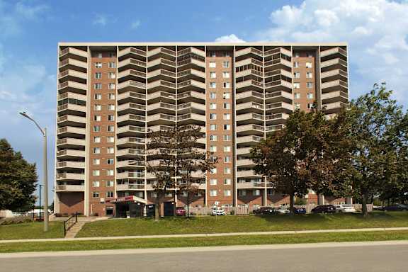 A large apartment building with a parking lot in front.
