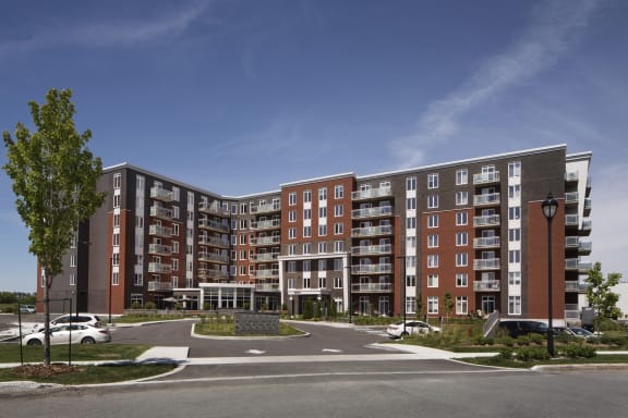 a rendering of a large apartment building in a parking lot