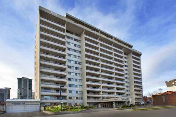 A large, modern building with a beige facade and multiple windows.