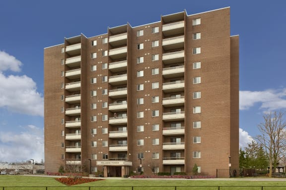 a tall brick building with balconies and a blue sky