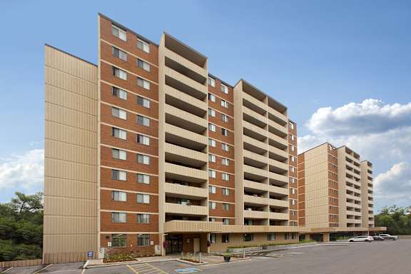 a tall building with a parking lot in front of it