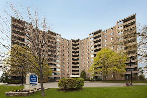 a view of a large apartment building with a park in front