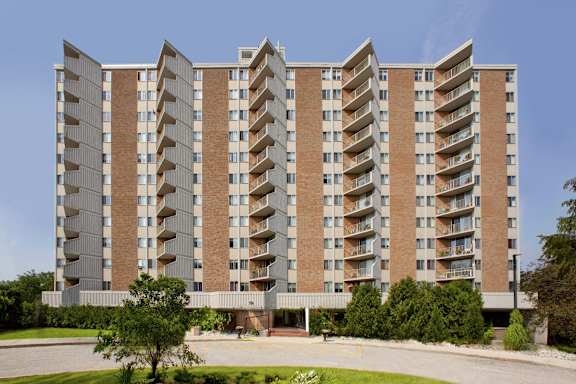 a large building with many balconies and trees in front of it