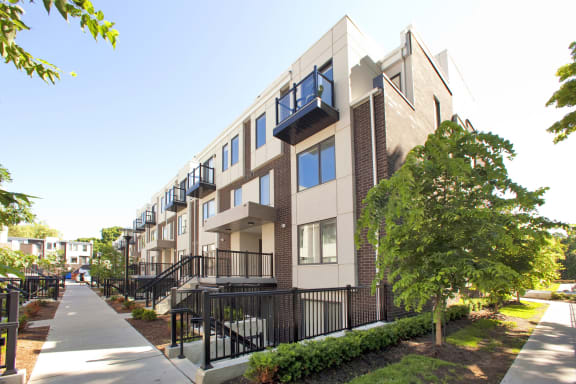 a row of apartment buildings with balconies and a sidewalk