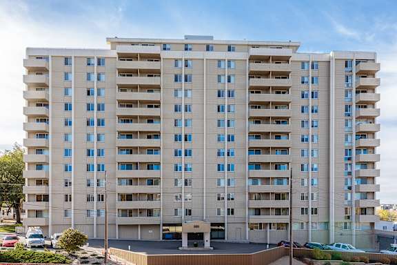 a large apartment building with balconies and cars parked in front of it